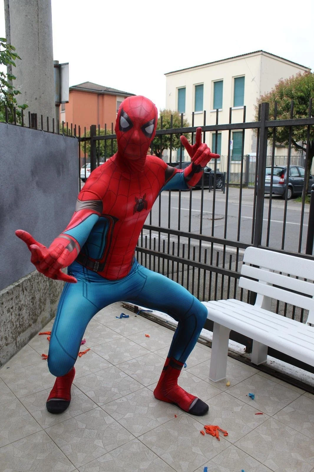 Persona in costume di Spider-Man in posa divertente su un balcone