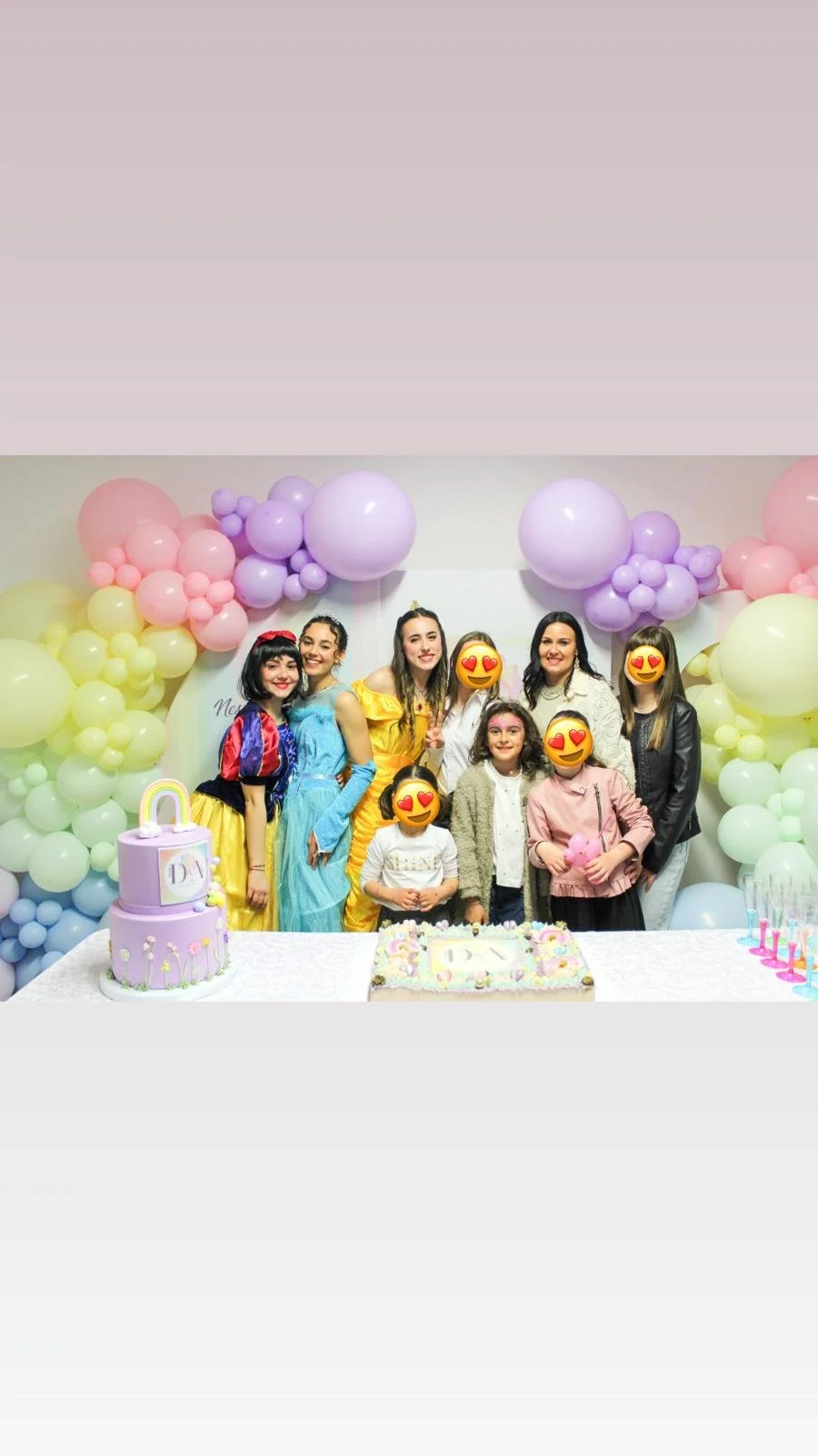Gruppo di persone che festeggiano una festa di compleanno con decorazioni colorate di palloncini e torte sulla tavola.